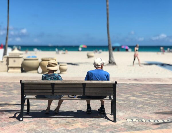 How to make happiness part of your financial plan Retired couple on bench overlooking beach