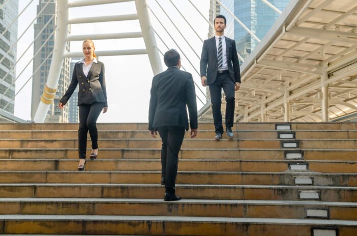 Three office workers crossing on some steps.