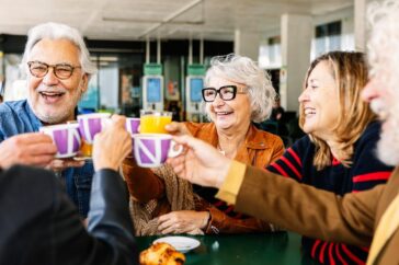 A group of people talking and drinking tea.