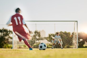 A footballer taking a shot at a goal.