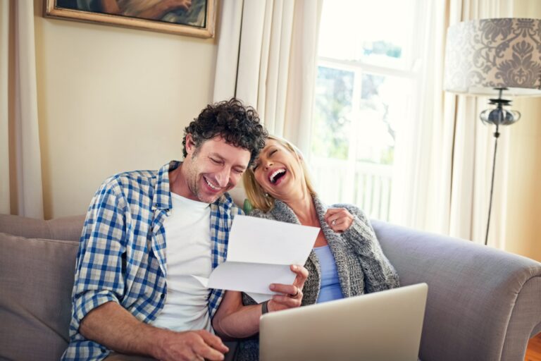 man on laptop with woman who is laughing