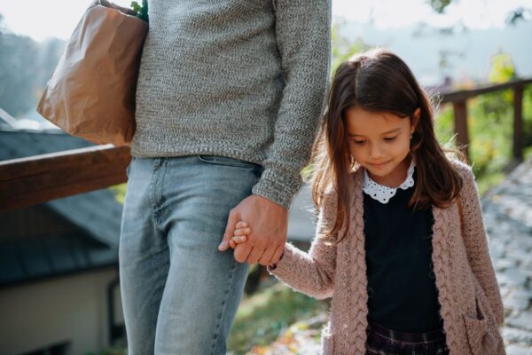 A mother and daughter holding hands.