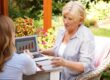 Female financial planner showing a senior woman charts on a laptop