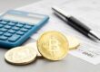 A representation of cryptocurrency next to a calculator.