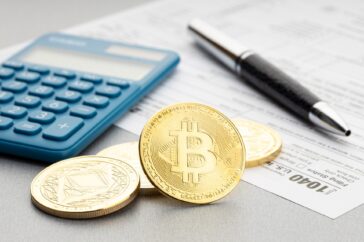 A representation of cryptocurrency next to a calculator.