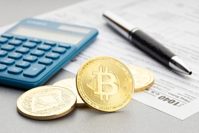 A representation of cryptocurrency next to a calculator.