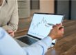 A man reviewing stock market movements on a laptop.