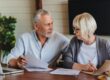 Smiling mature family looking at their bills