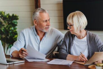 Smiling mature family looking at their bills