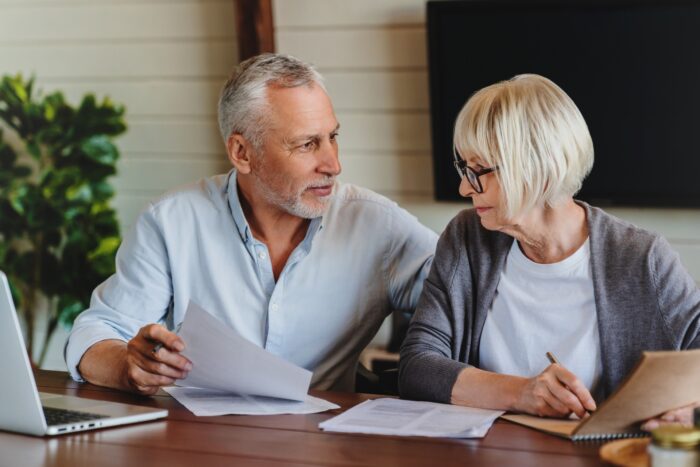 Smiling mature family looking at their bills