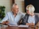Smiling mature family looking at their bills