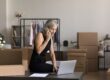 Female boss taking notes on a laptop as she discusses with someone on the phone