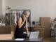 Female boss taking notes on a laptop as she discusses with someone on the phone